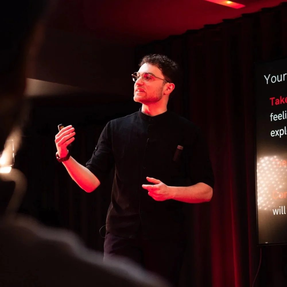 Seven Jacobs speaking on stage at TEDx